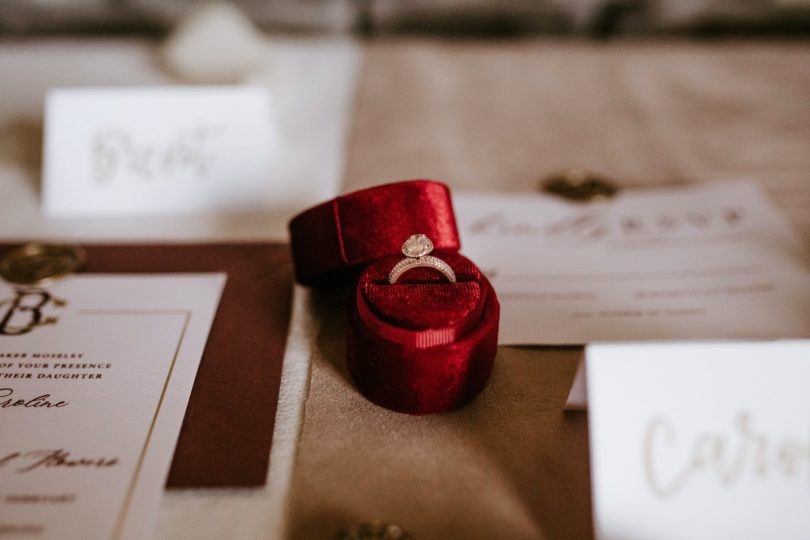 red box with golden ring placed on table with invitation cards (Jewelry)