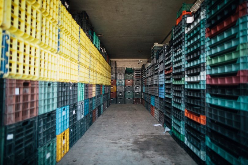 corridor between piles of containers in storehouse