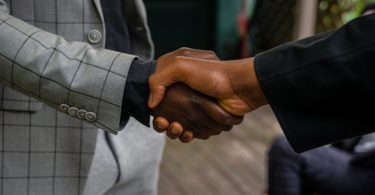 men in suit jackets shaking hands