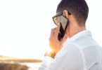 shallow focus photography of a man in white collared dress shirt talking to the phone using black android smartphone call