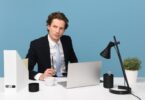 man sitting with laptop computer on desk and lamp