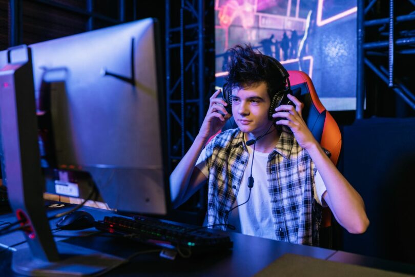 man in plaid shirt holding his headset