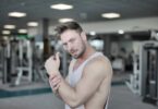 serious male athlete standing in gym and looking at camera