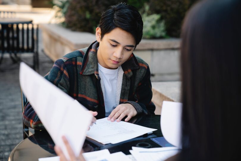 photo of a man in a white inner shirt studying