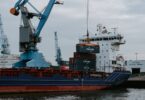 blue and red cargo ship with crane
