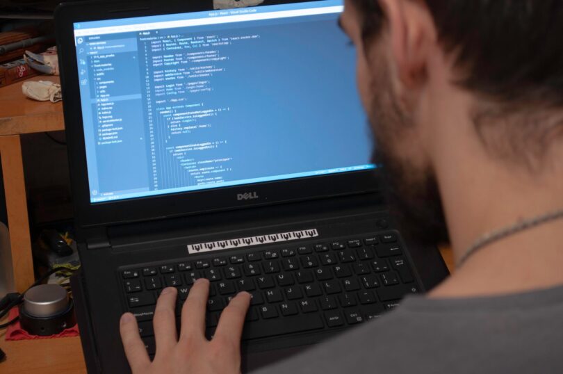 person using black dell laptop computer