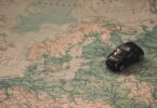 black toy car on world map paper