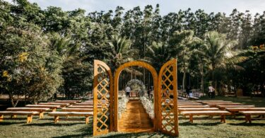 wedding arch and guest benches placed in verdant park
