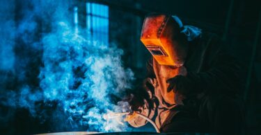 person welding wearing a prootective metal mask