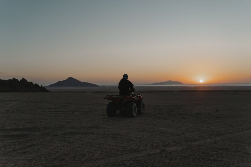person riding a quad bike in the desert