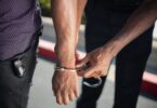 police officer putting handcuffs on another person