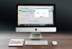 silver imac apple magic keyboard and magic mouse on wooden table
