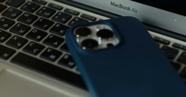 a blue phone case sitting on top of a laptop