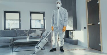 man in white suit standing beside white wall