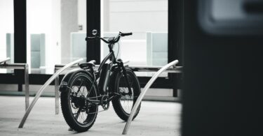 black city bike parked beside white wall